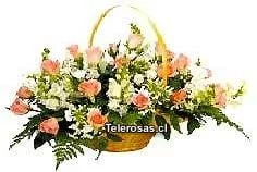 Delicada cesta ovalada con rosas pastel y complementos