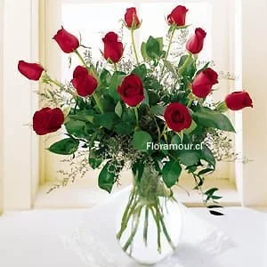 Florero de vidrio con 12 rosas y flores de complemento
